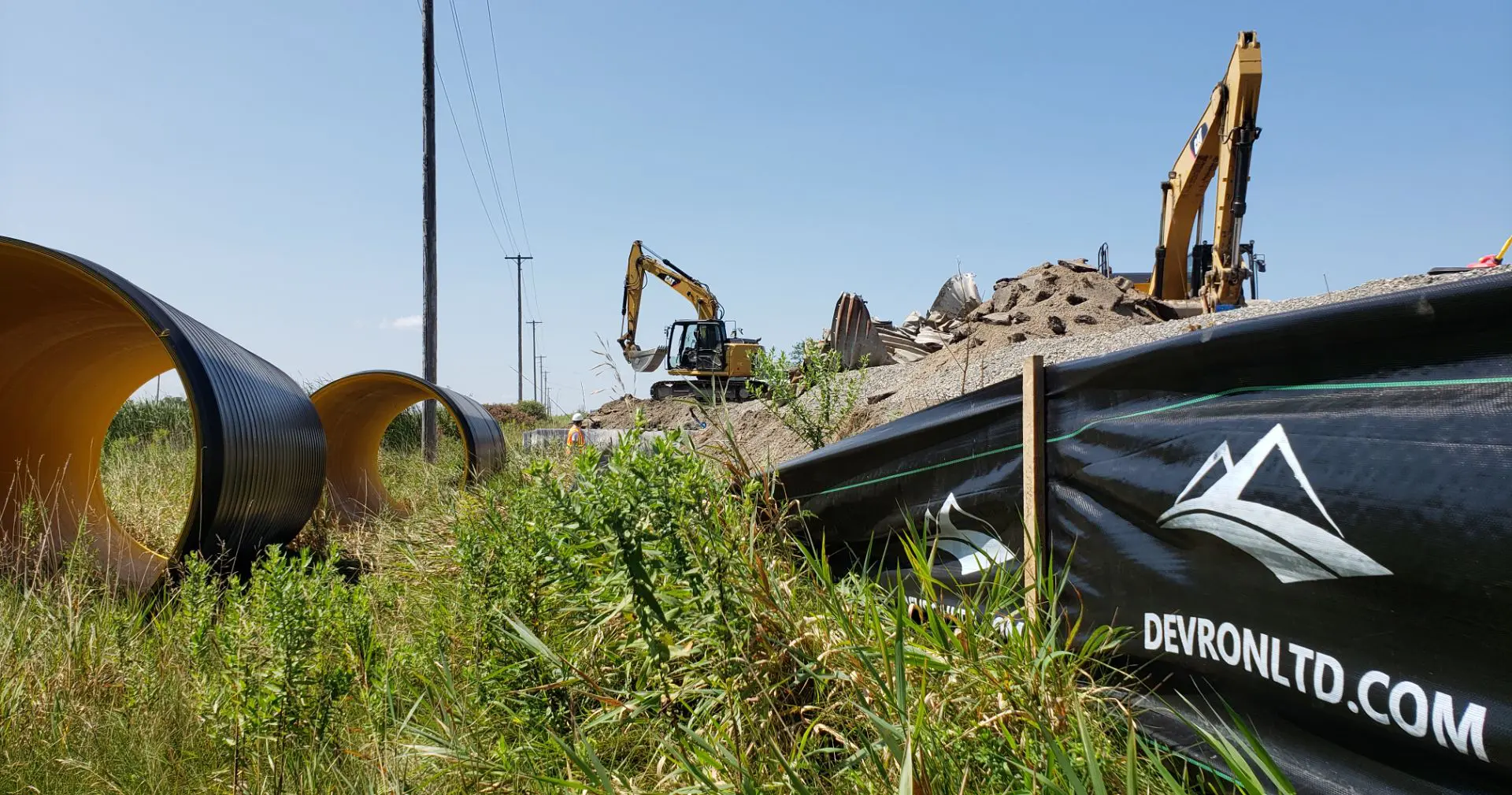 A yellow and black excavator in the grass