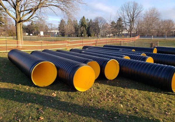 Large yellow-lined black pipes outdoors.